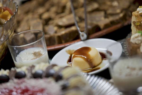 Eine Tafel mit verschiedenen Desserts, einschließlich Creme mit Karamellsauce, Glas Milch und weiteren süßen Gerichten.