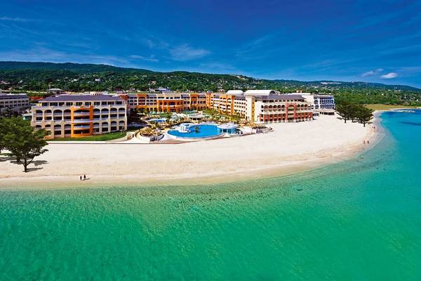 Luftaufnahme des Iberostar Selection Rose Hall Suites Hotels am Strand mit Swimmingpools und blauem Wasser.