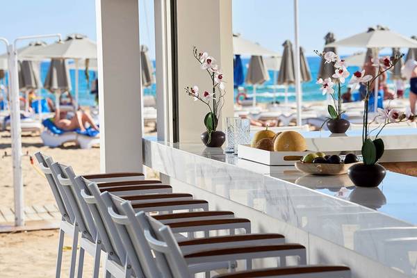 Innenansicht der Bar des Mythos Palace Resort & Spa mit Blick auf den Strand.