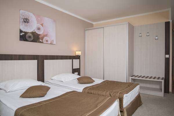 Doppelzimmer im DIT Evrika Beach Club mit zwei Betten, Dekor und Nachttischen.