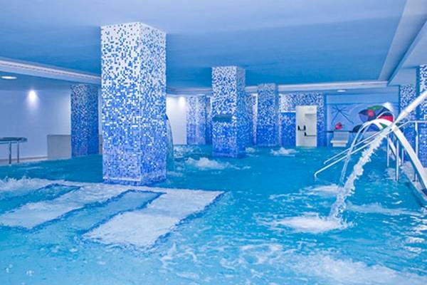 Innenpool des Alexandre Hotel Gala mit blauen Säulen und Wasserfällen.