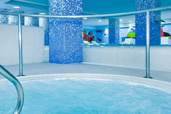 Innenpool des Alexandre Hotel Gala mit blauen Kacheln und fließendem Wasser.