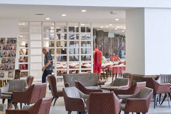 Innenbereich des Alexandre Hotel Gala mit Gästen, die sitzen und stehen, und Möbeln wie Stühlen und Tischen.