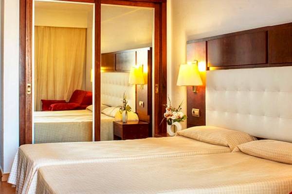 Doppelzimmer im Alexandre Hotel Gala mit zwei Betten und einem großen Spiegel.