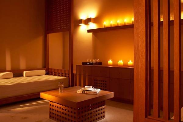 Innenbereich des Daios Cove Luxury Resort & Villas mit einem Bett, einem Tisch und Kerzen.
