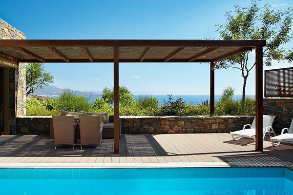 Terrasse mit Pool im Daios Cove Luxus Resort & Villas mit Blick auf das Meer.