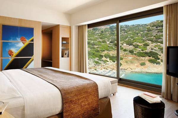 Luxuriöses Zimmer im Daios Cove Luxury Resort & Villas mit Aussicht auf das Meer und die Berge.