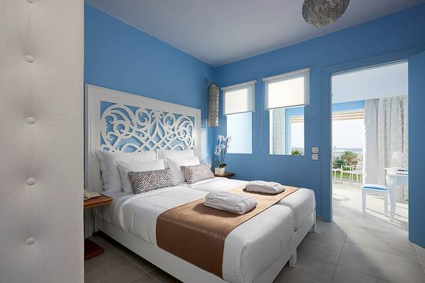 Doppelzimmer im Mythos Palace Resort & Spa mit zwei Betten und blauen Wänden.