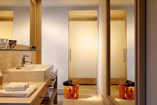 Badezimmer im Daios Cove Luxury Resort & Villas mit luxuriösem Waschbecken, Spiegel und Toiletten
