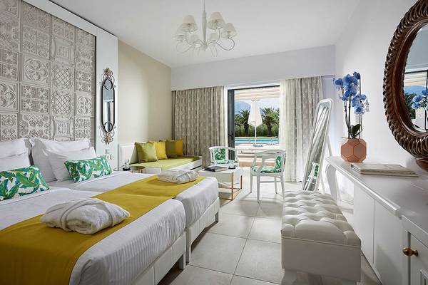 Luxuriöses Schlafzimmer im Mythos Palace Resort & Spa mit zwei Betten, Dekor und Aussicht auf den Pool.
