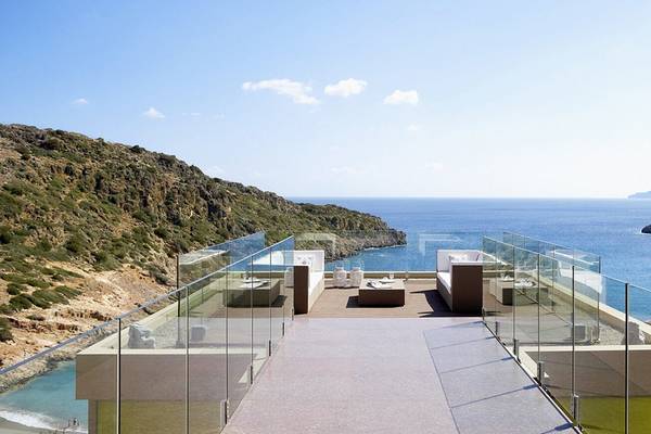 Terrasse des Daios Cove Luxury Resort & Villas mit Meerblick und Bergen im Hintergrund