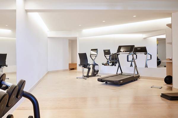 Fitnessraum im Daios Cove Luxury Resort mit Laufband und Hanteln.