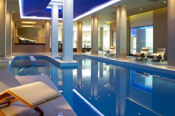 Luxuriöser Poolbereich im Daios Cove Luxury Resort & Villas mit Loungeliegen und blauem Wasser
