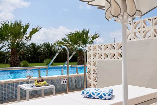 Poolbereich des Mythos Palace Resorts mit Sonnenschirm und Getränk