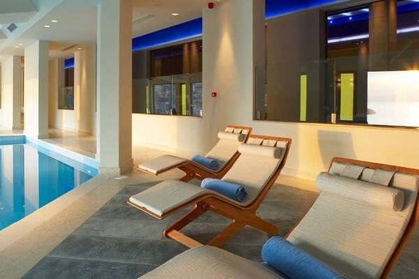 Poolbereich des Daios Cove Luxury Resort & Villas mit Liegen und blauem Wasser.