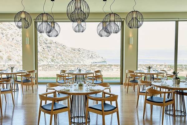 Innenansicht des Restaurants im Daios Cove Luxury Resort & Villas mit Blick auf die Berge und das Meer.