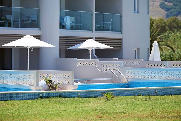 Außenpool mit Sonnenschirmen und Terrasse am Mythos Palace Resort & Spa