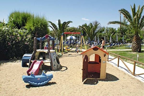 Kinderspielplatz im Poseidon Beach Hotel mit Sand, Spielgeräten und Sonnenschirmen.