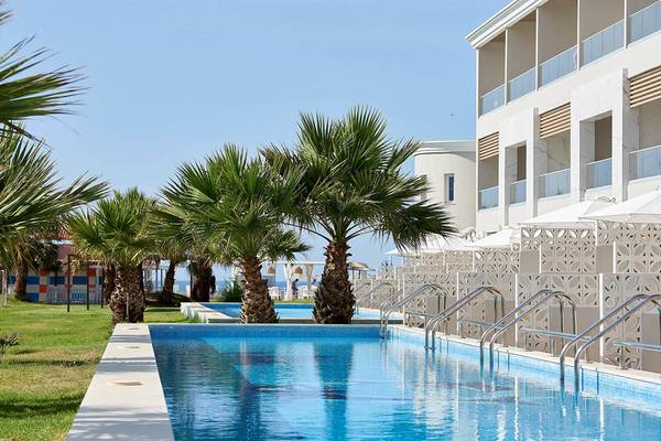 Poolbereich des Mythos Palace Resort & Spa mit Palmen und moderner Architektur.