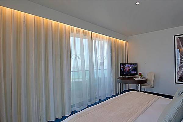 Zimmer im Crowne Plaza Abu Dhabi Yas Island mit Bett, Fernseher und Schreibtisch.