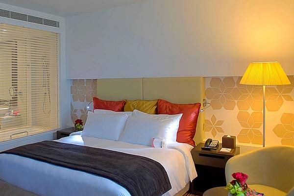 Hotelzimmer im Crowne Plaza Abu Dhabi Yas Island mit Bett, Kissen und Lampe.