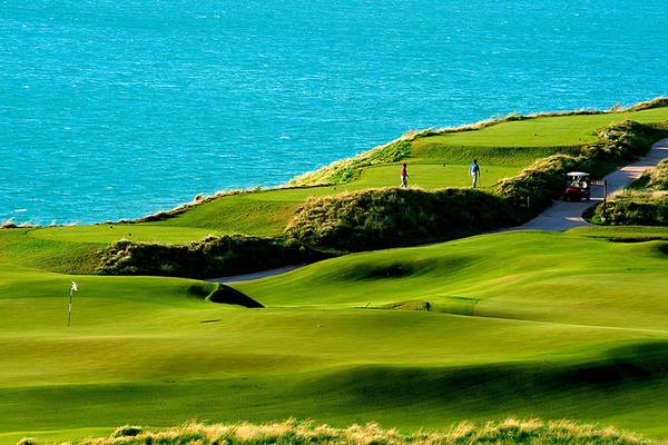 Golfplatz mit Blick auf das Meer und Golfern in der Ferne