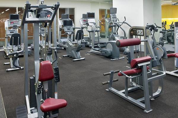 Innenansicht eines Fitnessstudios im Crowne Plaza Abu Dhabi Yas Island mit verschiedenen Trainingsgeräten und Spiegeln.