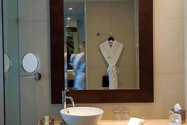 Badezimmer im Crowne Plaza Abu Dhabi Yas Island mit Spiegel und Handtuch.