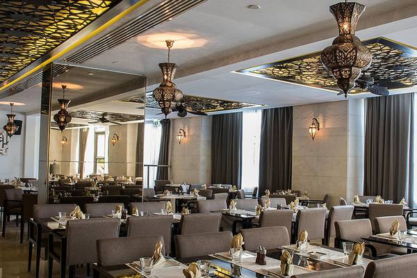 Innenbereich des Restaurants im Crowne Plaza Abu Dhabi Yas Island mit gedeckten Tischen und arabischen Lampen.