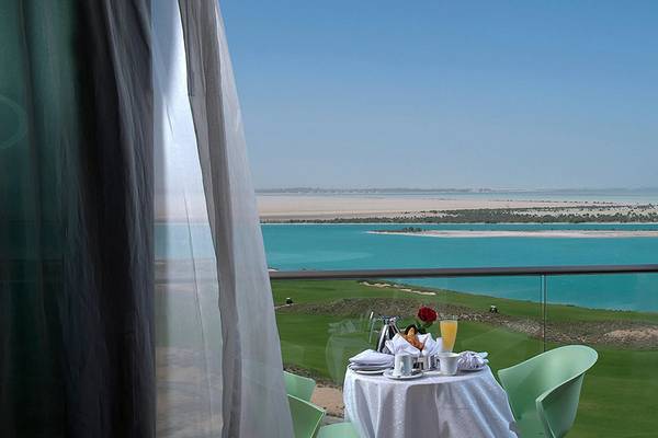 Blick aus dem Balkon des Crowne Plaza Abu Dhabi Yas Island auf den Golfplatz und das Wasser.