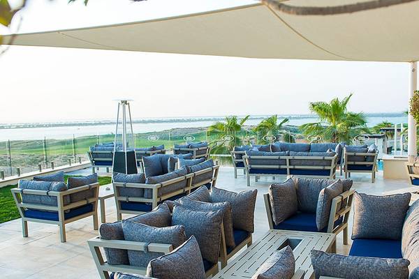 Terrasse des Crowne Plaza Abu Dhabi Yas Island mit Blick auf das Meer und Palmen