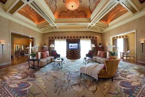 Luxuriöses Wohnzimmer im Atlantis The Palm mit großem Teppich, Sofas, Tisch, Fernseher und Deckenleuchte.