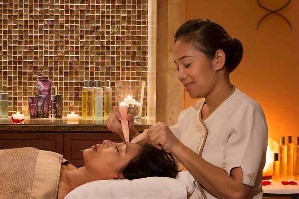 Eine Frau im Atlantis The Palm genießt eine Gesichtsmassage.