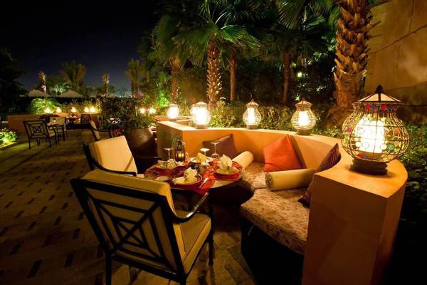 Terrasse des Atlantis The Palm Hotels bei Nacht mit illuminierten Lampen und Möbeln.