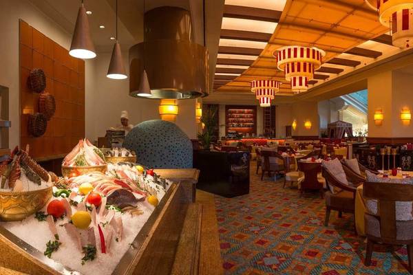 Innenansicht des Restaurants im Atlantis The Palm mit Fischbuffet, Tischen und Stühlen.