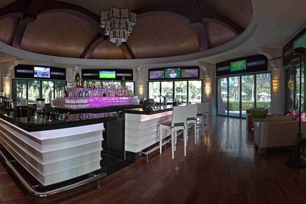 Innenansicht der Bar im Atlantis The Palm Hotel mit modernem Design, Sitzbereich und Fernsehern.
