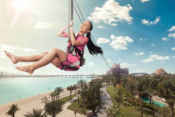 Ein Mädchen im pinken Outfit genießt eine Seilbahnfahrt im Atlantis The Palm.