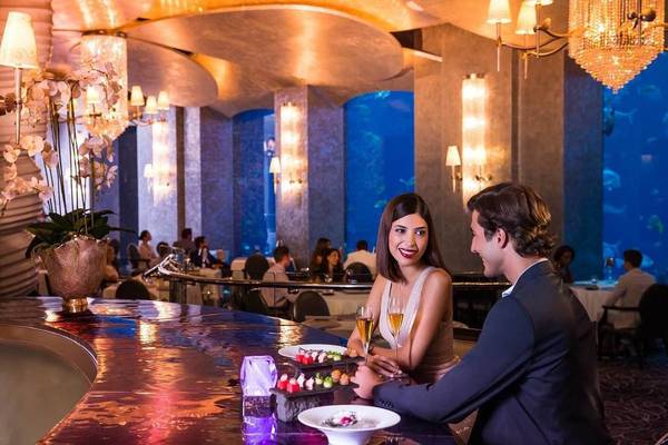 Ein Paar genießt eine Mahlzeit in einem eleganten Unterwasser-Restaurant im Atlantis The Palm.