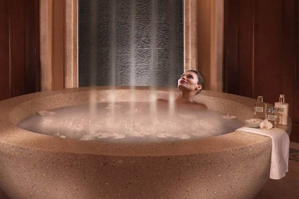 Frau genießt ein Bad in der runden Badewanne im Atlantis The Palm