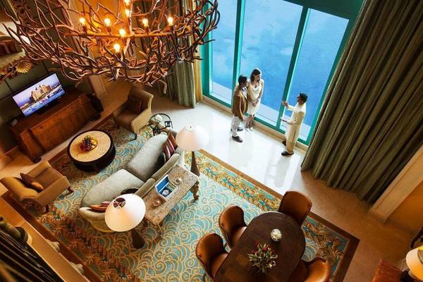 Innenansicht der Suite im Atlantis The Palm mit Wohnzimmer, Esstisch und Blick aufs Meer.