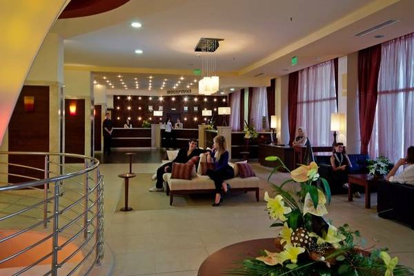 Innenansicht der Lobby im Sol Nessebar Palace Hotel mit Gästen und Rezeption.