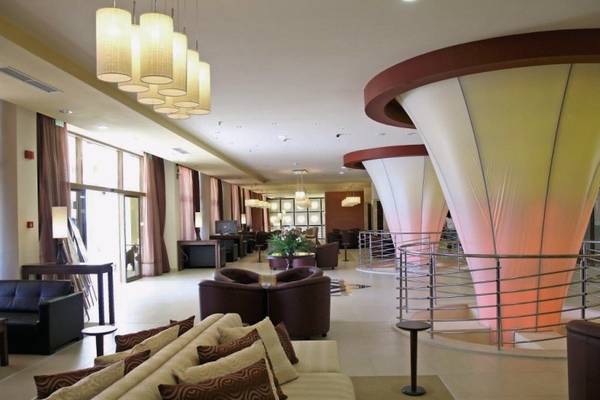 Innenansicht der Lobby des Sol Nessebar Palace All Inclusive Hotels mit Sofas, Sesseln und Stehlampen.