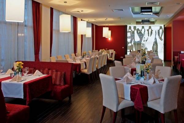 Innenansicht des Restaurants des Sol Nessebar Palace All Inclusive Hotels mit roten Möbeln und Dekoration.
