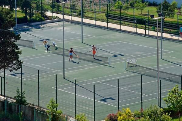 Tennisplatz mit mehreren Spielern im Sol Nessebar Palace All Inclusive Hotel.