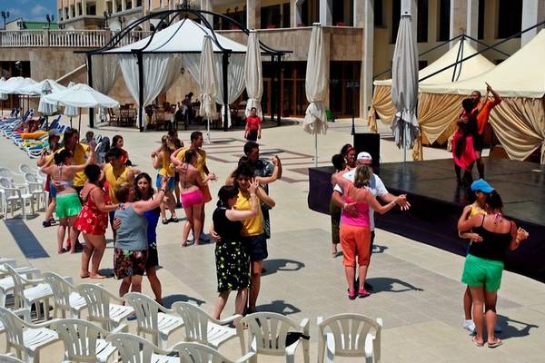 Gruppe von Menschen, die auf der Terrasse des Sol Nessebar Palace All Inclusive tanzen.