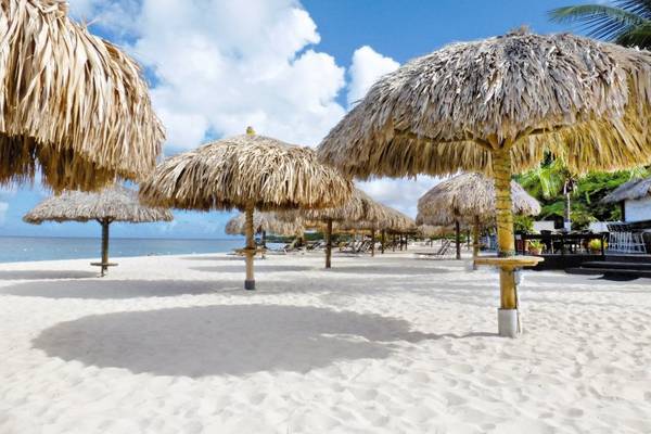 Strand des Amsterdam Manor Beach Resorts mit vielen Strohschirmen und weißem Sand