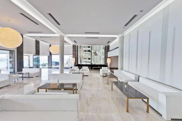 Lobby des Royal Marmin Bay Boutique Hotels mit weißen Möbeln und Marmorböden.