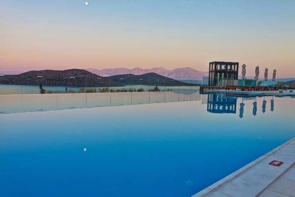 Royal Marmin Bay Boutique Hotel Pool bei Sonnenuntergang mit Blick auf die Berge