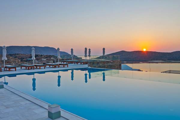 Sonnenuntergang am Pool des Royal Marmin Bay Boutique Hotels mit Blick auf das Meer und die Berge