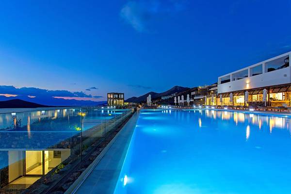 Außenpool des Royal Marmin Bay Boutique Hotels bei Nacht mit blauem Wasser und Beleuchtung.